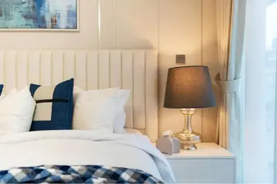 a bedroom with a bed and a lamp on a night stand at Guest Favorite - Relaxed and Cozy Studio Near Racecourse in Dubai