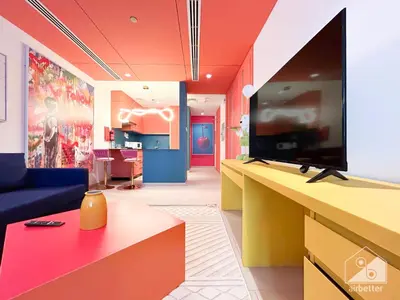 a living room with a flat screen tv and a couch at Colorful Studio with Balcony & City Views in Dubai
