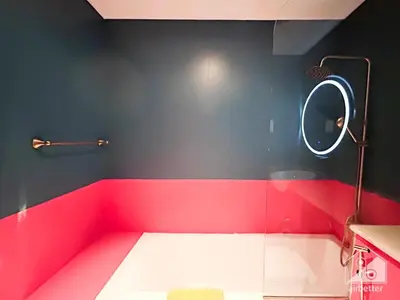 a bathroom with a red and black wall and a mirror at Colorful Studio with Balcony & City Views in Dubai