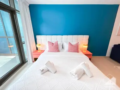 a bedroom with a large white bed with two pillows at Colorful Studio with Balcony & City Views in Dubai