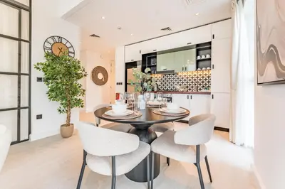 a kitchen and dining room with a table and chairs at Walk to Dubai Hills Mall, Premium Amenities And Near Dubai Hills Park And Golf Club, Socio Tower 1, Dubai Hills by Deluxe Holiday Homes in Dubai