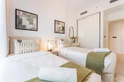 two beds in a room with white walls at Walk to Dubai Hills Mall, Premium Amenities And Near Dubai Hills Park And Golf Club, Socio Tower 1, Dubai Hills by Deluxe Holiday Homes in Dubai