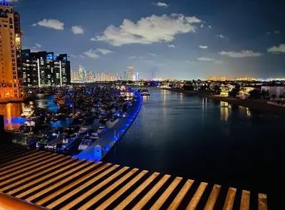a river with boats docked in a city at night at Luxury studio with full sea view in Dubai