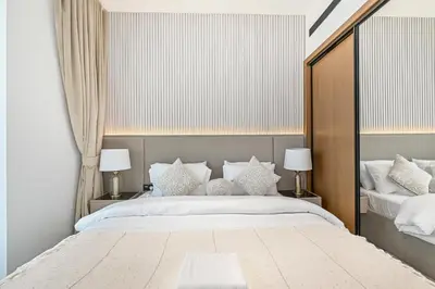 a bedroom with a large bed and two lamps at Golden Stays - Private Pool in Binghatti Onyx I Modern 2BR Apartment I JVC Dubai in Dubai
