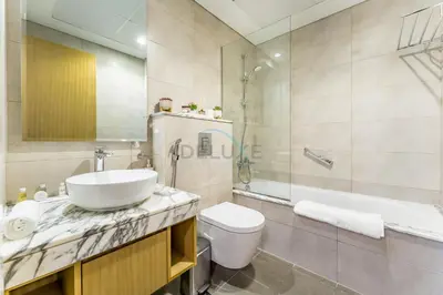 a bathroom with a sink and a toilet and a tub at Steps from Dubai Water Canal 2BR, Near Safa Park & SZR, Easy Downtown Access, Aykon City 2 Tower C, Business Bay by Deluxe Holiday Homes in Dubai