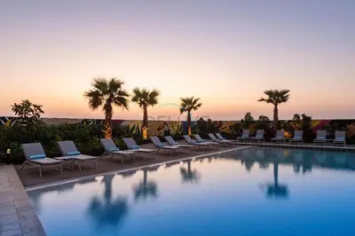 a swimming pool with lounge chairs and palm trees at Steps from Dubai Water Canal 2BR, Near Safa Park & SZR, Easy Downtown Access, Aykon City 2 Tower C, Business Bay by Deluxe Holiday Homes in Dubai