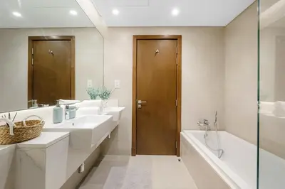 a bathroom with two sinks and a tub and a shower at Stunning 1BR Canal Front Residence near Downtown in Dubai