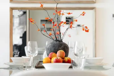 a table with a vase with flowers and apples on it at Stunning 1BR Canal Front Residence near Downtown in Dubai