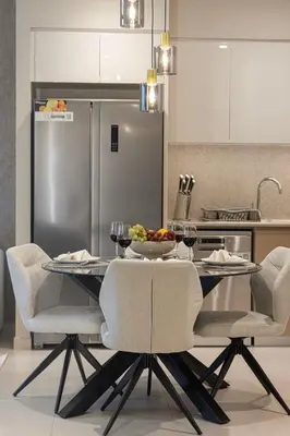 a kitchen with a table with chairs and a refrigerator at Burj Khalifa & Fountain Balcony Views, Pool & Gym in Dubai