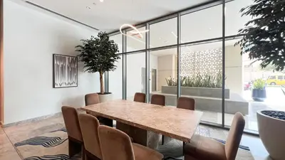 a dining room with a wooden table and chairs at Burj Khalifa & Fountain Balcony Views, Pool & Gym in Dubai