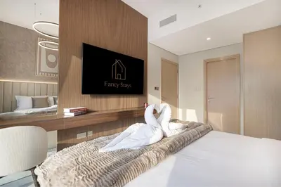 two swans sitting on a bed in a hotel room at Burj Khalifa & Fountain Balcony Views, Pool & Gym in Dubai