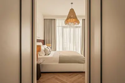 a mirror reflecting a bedroom with a bed and a window at Seraya Residences at Marina Vista, Emaar Beachfront in Dubai