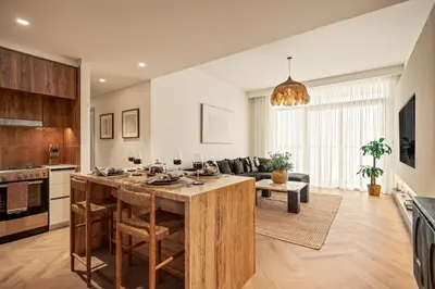 a kitchen and living room with a table and a couch at Seraya Residences at Marina Vista, Emaar Beachfront in Dubai