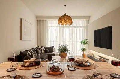 a living room with a table with glasses of wine at Seraya Residences at Marina Vista, Emaar Beachfront in Dubai