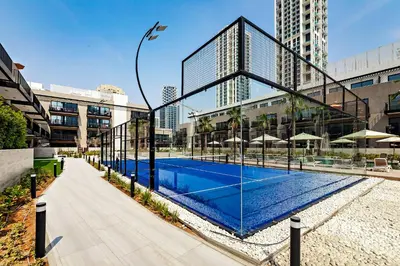 a building with a swimming pool in front of a building at Oakley Square 1BR Apartment with maid's room in Dubai