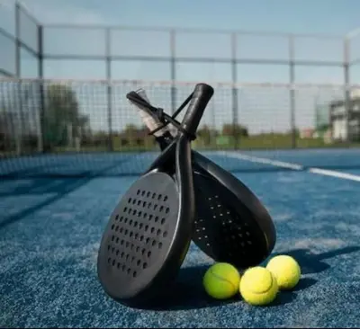 a tennis racket and three tennis balls on a tennis court at Oakley Square 1BR Apartment with maid's room in Dubai
