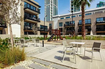 a patio with a table and chairs and a playground at Oakley Square 1BR Apartment with maid's room in Dubai