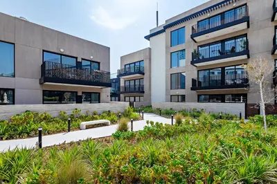 an apartment building with a garden in front of it at Oakley Square 1BR Apartment with maid's room in Dubai