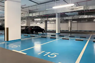 a parking garage with a car parked in it at Oakley Square 1BR Apartment with maid's room in Dubai