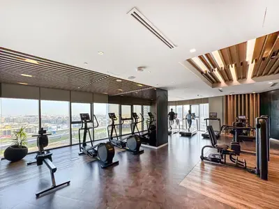 a gym with treadmills and ellipticals in a building at Famous Infinity Pool with Burj Khalifa View on High Floor in Dubai