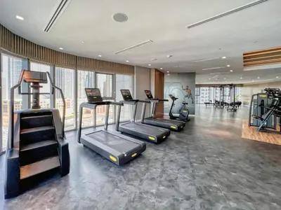 a gym with treadmills and exercise equipment in a room at Famous Infinity Pool with Burj Khalifa View on High Floor in Dubai