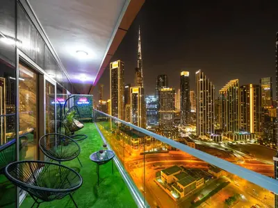 a balcony with chairs and a view of a city at Famous Infinity Pool with Burj Khalifa View on High Floor in Dubai
