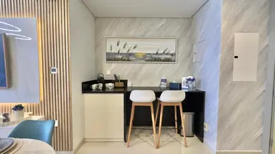 a kitchen with two stools at a counter in a room at Guest Favorite - 2BR Apartment 57th Floor Close to Downtown in Dubai
