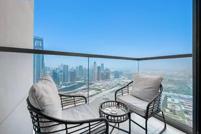 a balcony with two chairs and a view of the city at Guest Favorite - Premium 3BR with Skyline Views at Floor 50 in Dubai
