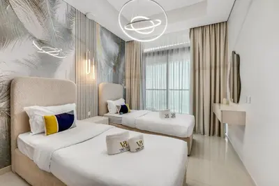 a hotel room with two beds and a chandelier at Guest Favorite - Premium 3BR with Skyline Views at Floor 50 in Dubai