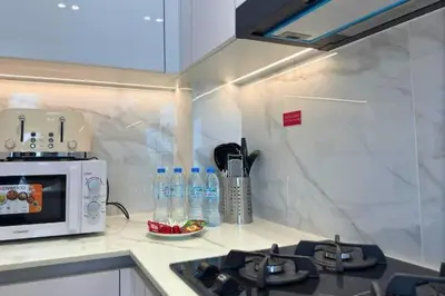 a kitchen with a microwave and a counter top at Guest Favorite - Minimalist 1BR Escape with Balcony in the Heart of JVC in Dubai