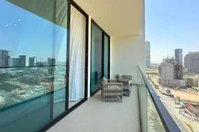 a balcony with chairs and a view of a city at Guest Favorite - Minimalist 1BR Escape with Balcony in the Heart of JVC in Dubai