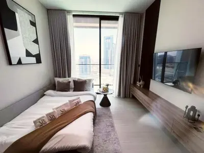two beds in a hotel room with a large window at Guest Favorite - Minimalist 1BR Escape with Balcony in the Heart of JVC in Dubai