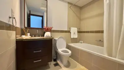 a bathroom with a toilet and a sink and a tub at Guest Favorite - Calm and Classy 1BR on High Floor - Walk to Dubai Mall in Dubai