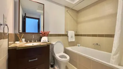 a bathroom with a toilet and a sink and a tub at Guest Favorite - Calm and Classy 1BR on High Floor - Walk to Dubai Mall in Dubai