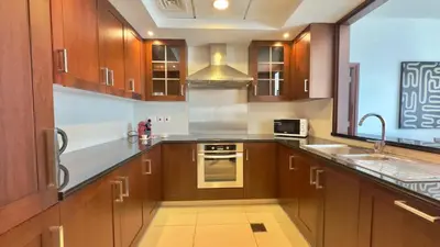 a kitchen with wooden cabinets and a sink and a stove at Guest Favorite - Calm and Classy 1BR on High Floor - Walk to Dubai Mall in Dubai