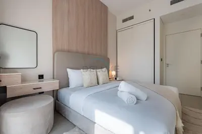 a bedroom with a large white bed and a mirror at Steps from Dubai Hills Mall, Surrounded by Top-Tier Amenities, and close to Dubai Hills Park and Golf Club, Socio Tower 1, Dubai Hills by Deluxe Holiday Homes in Dubai
