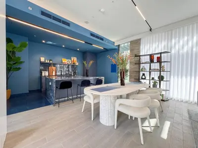 a dining room with a table and chairs and a bar at Premium 2BR with Pool, Gym & Lifestyle Amenities in Dubai