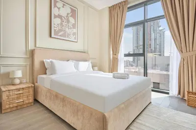 a bedroom with a large bed and a large window at Premium 2BR with Pool, Gym & Lifestyle Amenities in Dubai