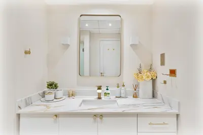 a white bathroom with a sink and a mirror at Upmarket - 1BR - Canal View - 9 MIN Dubai Mall in Dubai