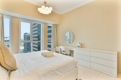 a bedroom with a bed and a desk and a window at Upmarket - 1BR - Canal View - 9 MIN Dubai Mall in Dubai