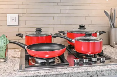 two pots and pans on a stove in a kitchen at Golden Stays - Luxury 2BR I Burj Views & Direct Dubai Mall Access in Dubai
