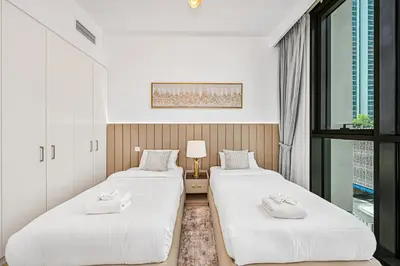 two beds in a room with a window at Golden Stays - Luxury 2BR I Burj Views & Direct Dubai Mall Access in Dubai