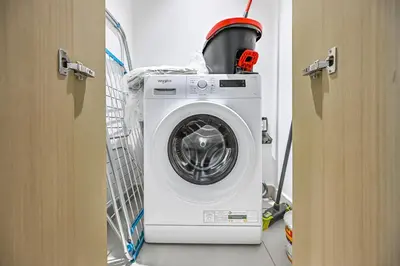 a washing machine in a laundry room with its door open at Golden Stays - Luxury 2BR I Burj Views & Direct Dubai Mall Access in Dubai