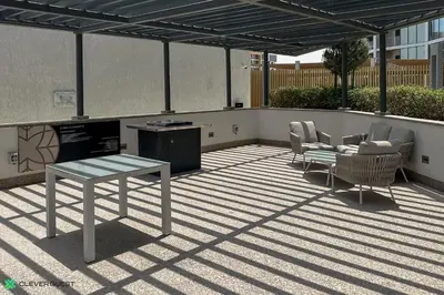 a patio with a table and chairs on a roof at Clever Guest 032 Hartland Waves in Dubai