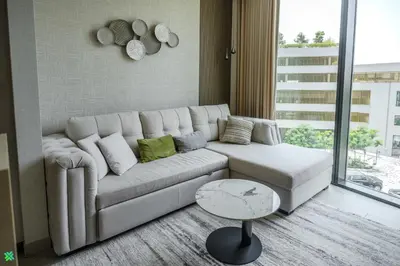 a living room with a white couch and a table at Clever Guest 032 Hartland Waves in Dubai
