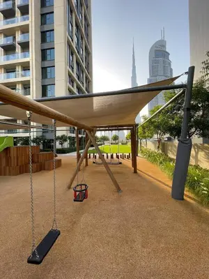 a swing set in the middle of a city at Downtown Pulse Artful 1BR with Dubai Mall Access by Maxx Value Homes in Dubai