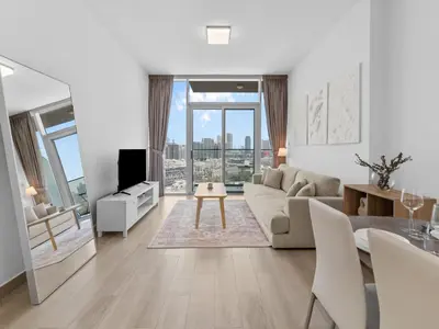 a living room with a couch and a table at Bright 1 Bedroom Apartment with JVC open view in Dubai