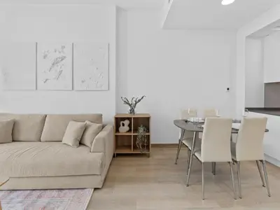 a living room with a couch and a table at Bright 1 Bedroom Apartment with JVC open view in Dubai