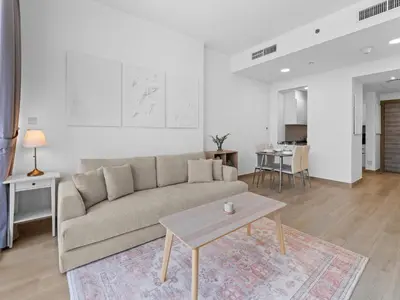 a living room with a couch and a table at Bright 1 Bedroom Apartment with JVC open view in Dubai