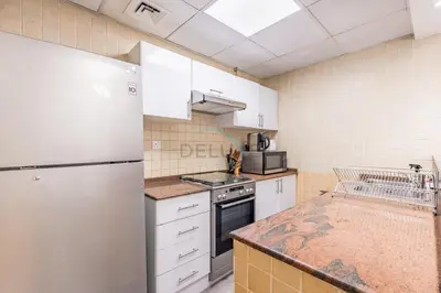 a kitchen with white appliances and a white refrigerator at Metro-Accessible 2BR, Easy Reach to Marina Mall and JBR Beach, Featuring Stunning SZR & City Views, Marina Diamond 2, Dubai Marina by Deluxe Holiday Homes in Dubai